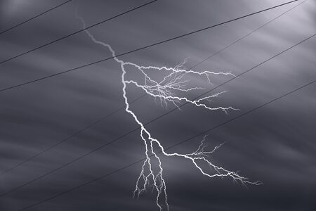 High voltage power line cables with lightning and dark skyの写真素材