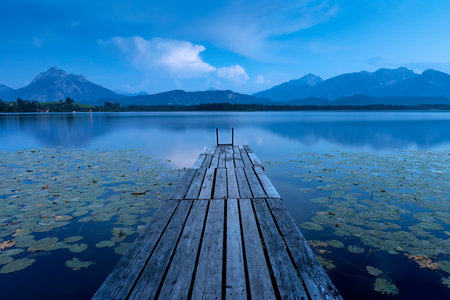 Jetty on Lake Hopfensee in the AllgÃ¤u (Bavaria) in summer during the blue hourの写真素材