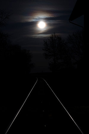 Rising full moon over a single railway line in rural Bavaria, Germanyの写真素材