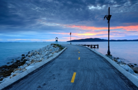 Sunrise over road on the seaの写真素材
