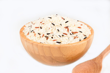 Raw rice in the wood bowl on white backgroundの写真素材