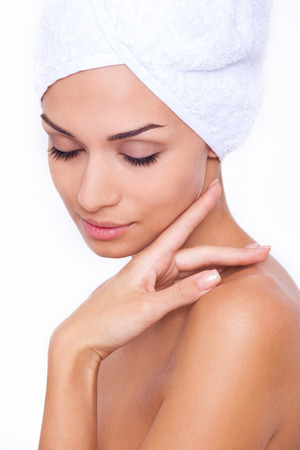 Pure beauty. Beautiful young shirtless woman touching her face and keeping eyes closed while isolated on white backgroundの写真素材