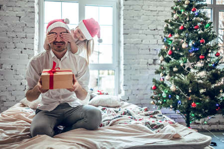 I got a present for you. Daughter giving her senior father a surprise present. The girl closes her father's eyes to give a giftの写真素材