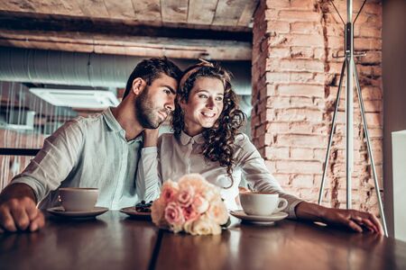 Beautiful couple spends time together. They hug each other and looking at the window.の写真素材