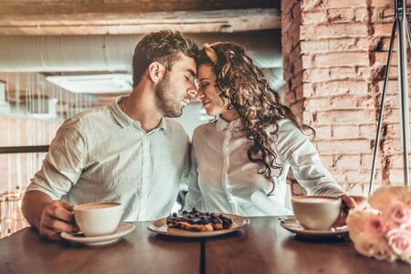 You are my Everything.Beautiful couple in love hugging each other sitting in restaurant.の写真素材
