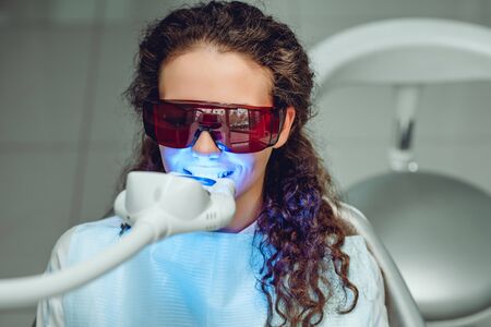 Teeth whitening for woman. Bleaching of the teeth at dentist clinic. Front view.の写真素材