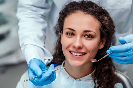 Health check. Dentist in stomatology center is making an examination of girl teeth by using dental tools.の写真素材