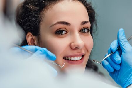 Smiling woman sitting in dentist chair ready for a dental check-up. Close up view.の写真素材