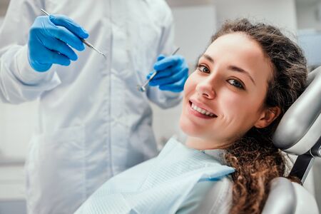 Smiling young woman receiving dental checkup. close up view. Healthcare and medicine concept.の写真素材