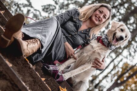 They best friends.Bottom view of beautiful smiling woman with dog in the park.