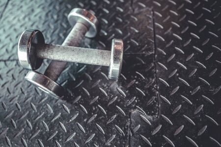 Dumbbells on empty floor in Gym. Copy space. Sport conceptの写真素材