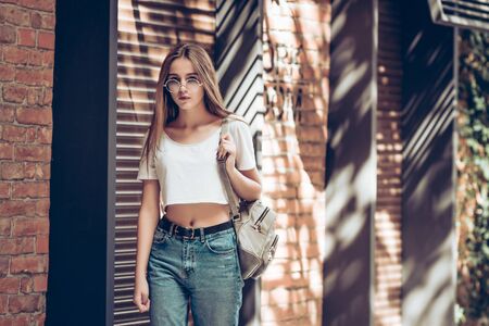 Portrait of a happy woman in the city. Fashion woman walking outdoors in city street and posing at camera.の写真素材