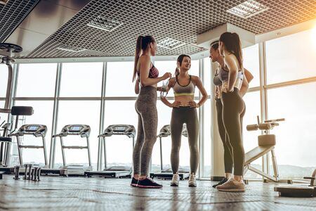 Group of friends talking in a fitness center after hard training day.の写真素材