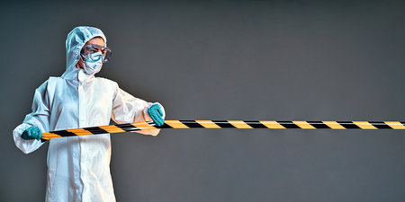 quarantine and pandemic concept - healthcare worker in protective gear or hazmat suit, medical mask,...