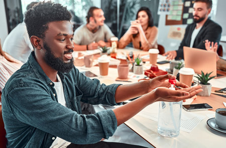 Businessmen use alcohol gel hand press That is placed in the corner of the working table There are notebooks and document files nearby. Concept COVID-19, work style adjustment, adaptationの写真素材