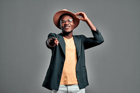 Young cool black man pointing you on gray background. Copy spaceの写真素材