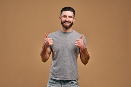 Portrait of a handsome young man showing thumbs up.