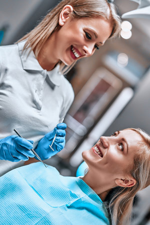 A smiling woman at the dentist ready for a check-up. Vertical photoの写真素材