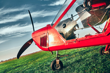 Small lightweight private airplane standing on airfield grass. Copyspace