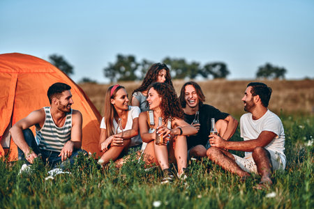 Group of friends having fun outside tents on camping holiday.の写真素材