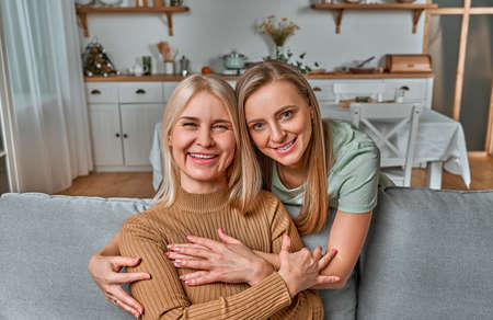 Mom, I am grateful to you for everything, you are the best in the world! an adult daughter hugs her old mother and smiles.Parental love.の写真素材
