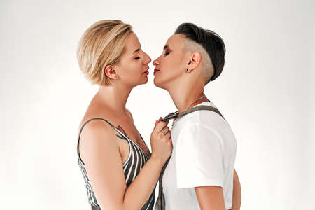 A kiss between two women on white background. LGBT. Lesbian couple love moments happiness concept.の写真素材