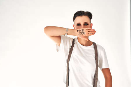 Woman with me too lettering on hand covering mouth isolated on white, gender inequality concept. Copy space.の写真素材