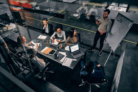 A group of handsome business people working in a spacious conference room in a large business...