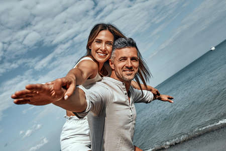 Cheerful young couple enjoying the summer time on the beach. Close up viewの写真素材