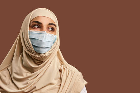Close-up portrait of a muslim woman in a mask. The concept of medicine, health care.の写真素材