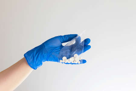 Holding white color capsules on white background.の写真素材