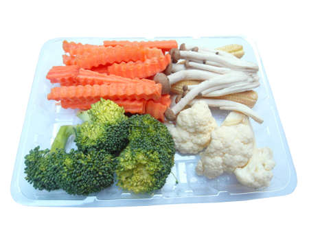 Vegetables are placed on a separate plastic box on a white backdrop.の写真素材