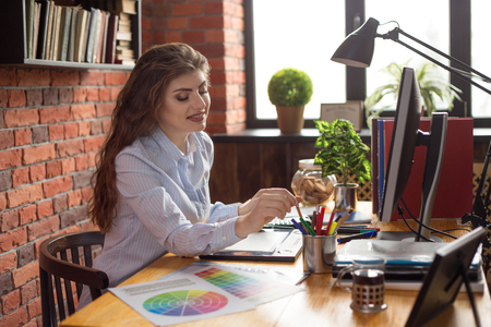 Young Beautiful female desiner or graphic artist at work place at loft style office.の写真素材