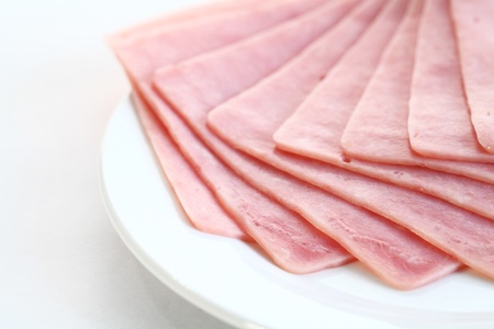 Slices of tasty ham on white dish.の写真素材
