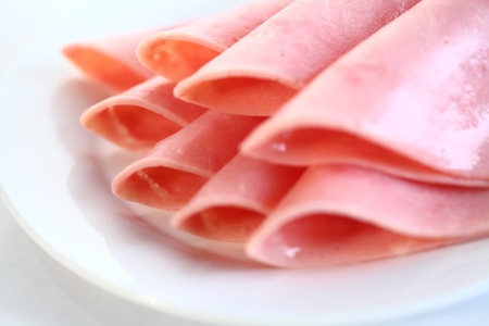 Slices of tasty ham on white dish.の写真素材
