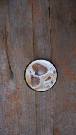 Iced coffee on wooden table. Top view with copy space.