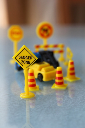 car Accident zone cordoned off with a yellow stop sign post. two cars with a major collision with one car toppled by another brown car & area cordoned by yellow barricadesの写真素材