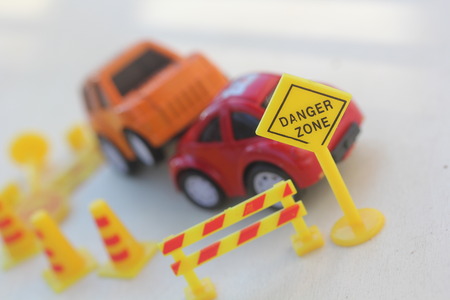 car Accident zone cordoned off with a yellow stop sign post. two cars with a major collision with...