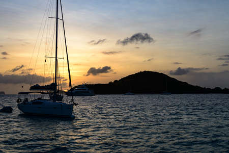 Sunset in the Tobago Cays - Saint Vincent and The Grenadines with sailing yacht in the backgroundの写真素材