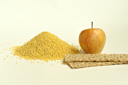 Dietary breakfast. Apple, stack of crispbread and a handful of millet on a light background. Focus on the apple and millet.の写真素材