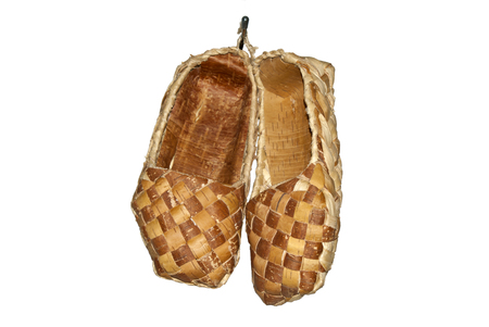 traditional ancient woven bast shoes hanging on the wall isolatedの写真素材