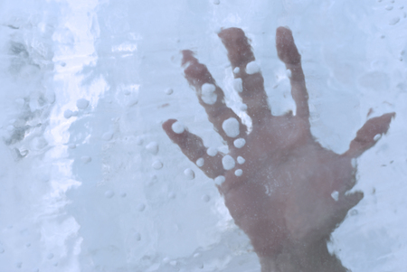 human hand in a block of ice or under ice, closeupの写真素材