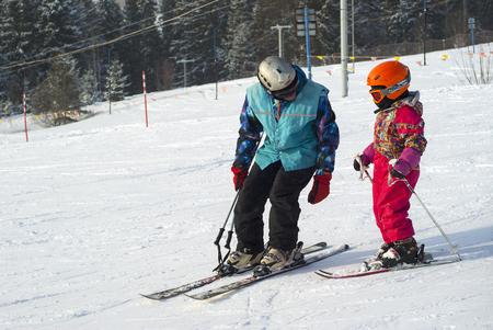 PERM, RUSSIA - FEBRUARY 24, 2018: man teaches a child skiing on a snowy mountainsideのeditorial素材