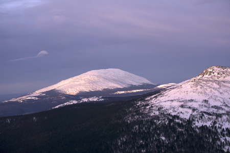 snow-capped mountain peaks of the northern ural, illuminated by the low morning sun,