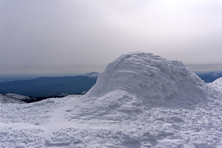 View from the firn-covered mountain peak to the winter valley