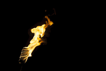 Flame of a torch in the dark on a black background, only the fire is visibleの写真素材