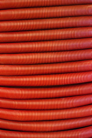 vertical background - red corrugated flexible polymer tubes close upの写真素材