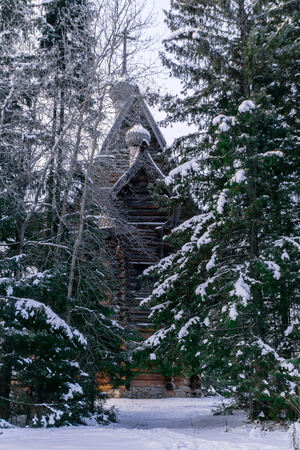 traditional vintage old wooden church in the winter forestの写真素材