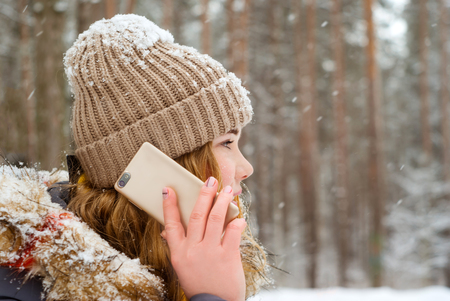 girl speak on the phone in the winter parkの写真素材