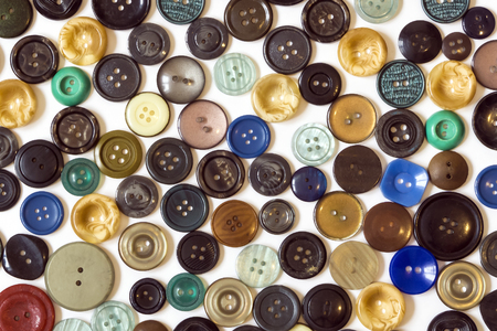 background - multicolored plain buttons chaotically arranged on a white surfaceの写真素材